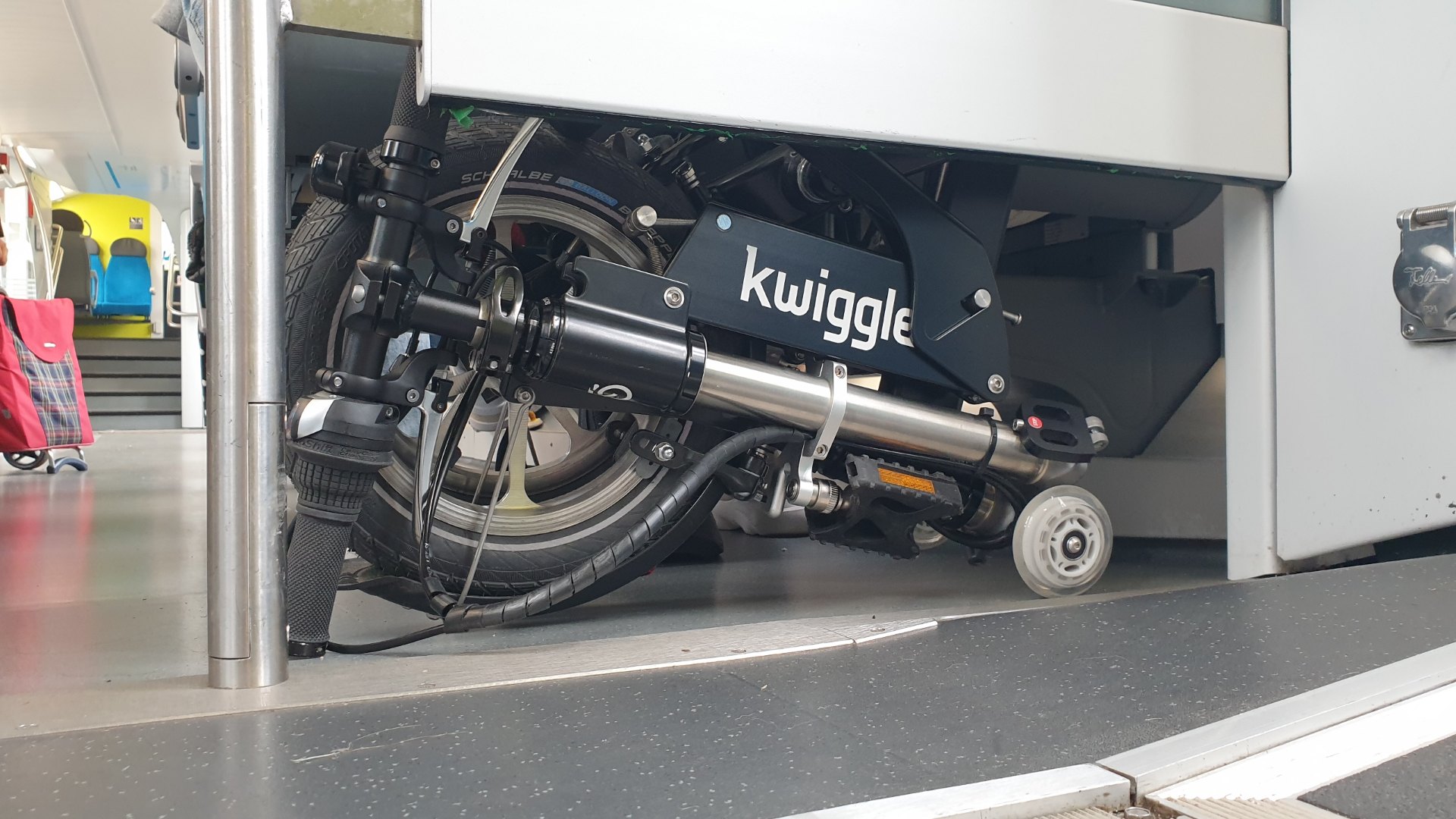 Bicicleta-plegable-Kwiggle-detrás-del-asiento-del-tren